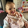toddler, child, smiling, tongue_out, pink_jacket, white_shirt, high_chair, indoor, face, cute, happy, person, baby, seatbelt, furniture, toy, background_blur, clothing, portrait, expression