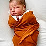 newborn, baby, infant, sleeping, swaddled, blanket, orange, knit, portrait, face, closed_eyes, nose, mouth, head, white_background, soft_lighting, cozy, indoors, photography, burrito