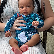 Kyree joined the competition — help win amazing prizes! adult, baby, braids, chair, child, clothing, expression, feet, hand, holding, indoor, infant, knitted_dress, pattern, person, portrait, sitting, skin, tattoo, woman
