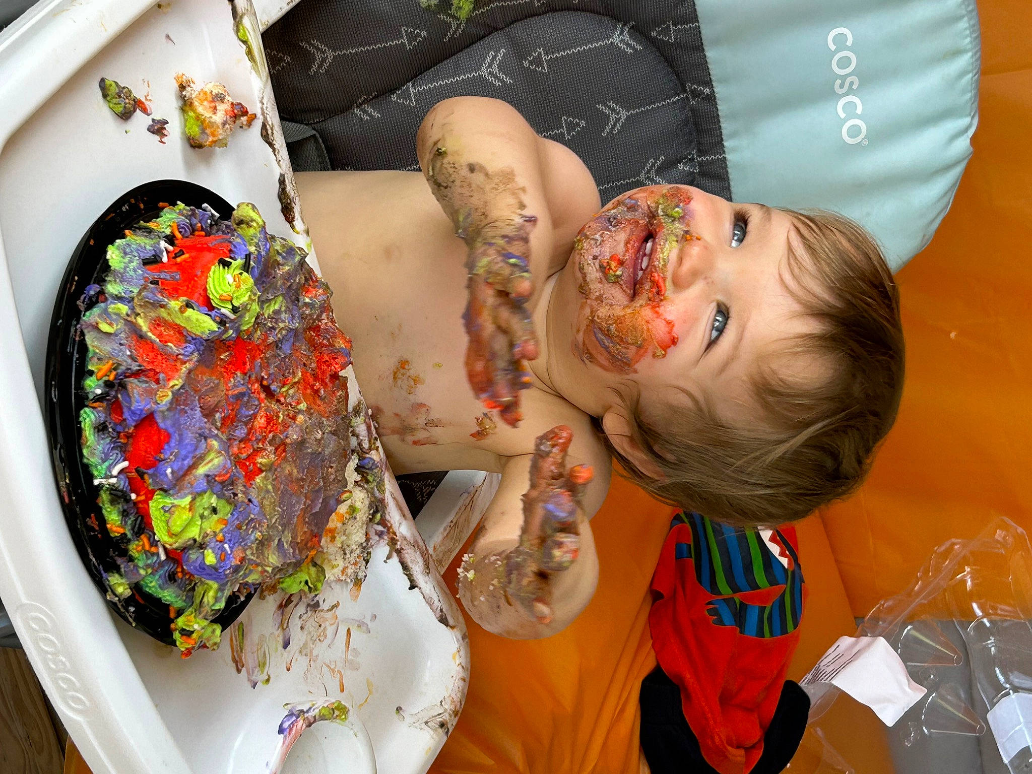 Elijah is registered to the contest to win money with this photo: art, artist, birthday_cake, chair, child, dessert, event, food, fun, happy, orange, pattern, person, plate, platter, room, sugar_cake, tableware, textile, toddler