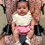 Evelyn is registered to the contest to win money with this photo: baby, child, car_seat, floral_pattern, pink_clothing, white_shoes, bows, infant, cute, indoor, portrait, person, seat_belt, fabric, footwear, skin, headwear, expression, sitting, young_child