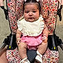 baby, child, car_seat, floral_pattern, pink_clothing, white_shoes, bows, infant, cute, indoor, portrait, person, seat_belt, fabric, footwear, skin, headwear, expression, sitting, young_child