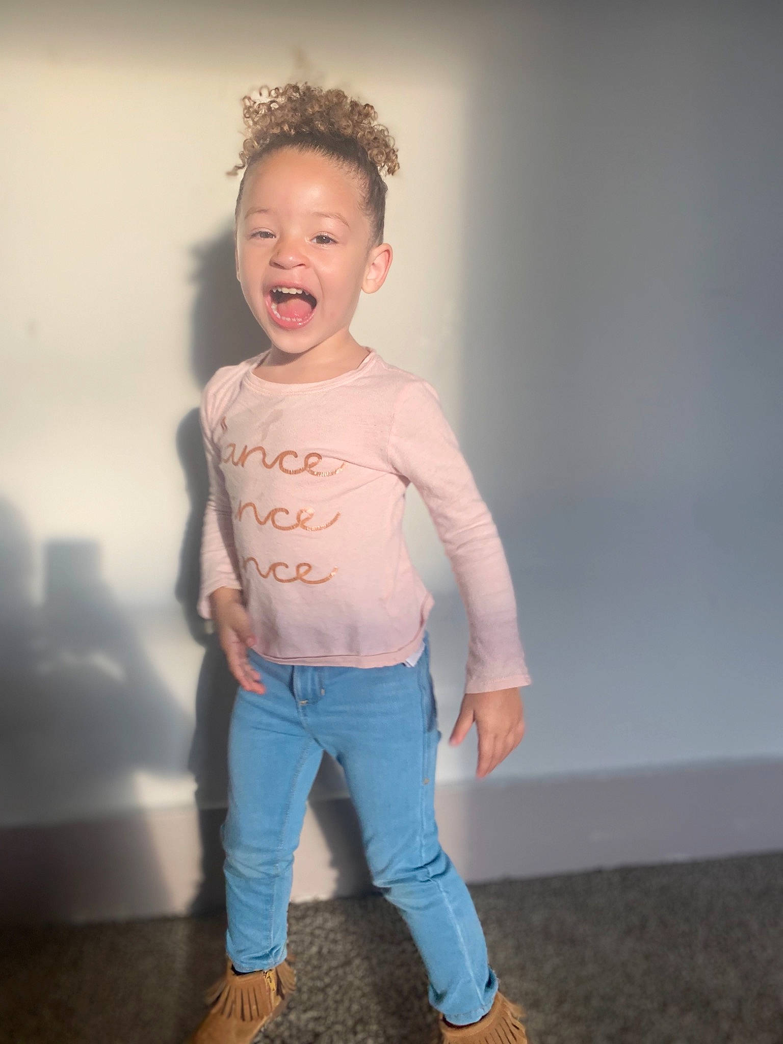 Analia is registered to the contest to win money with this photo: child, child_model, face, footwear, fun, head, jeans, joint, leg, outerwear, person, pink, shoulder, skin, sleeve, smile, standing, t_shirt, toddler, white