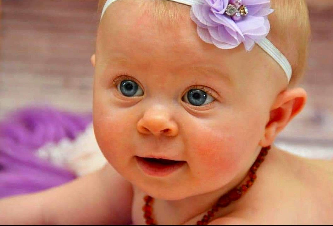 Inaé a rejoint le concours — aidez-le/la à gagner de superbes lots ! baby, cheek, ear, eye, eyebrow, eyelash, face, flower, gesture, happy, head, headpiece, iris, lip, nose, person, pink, plant, skin, smile