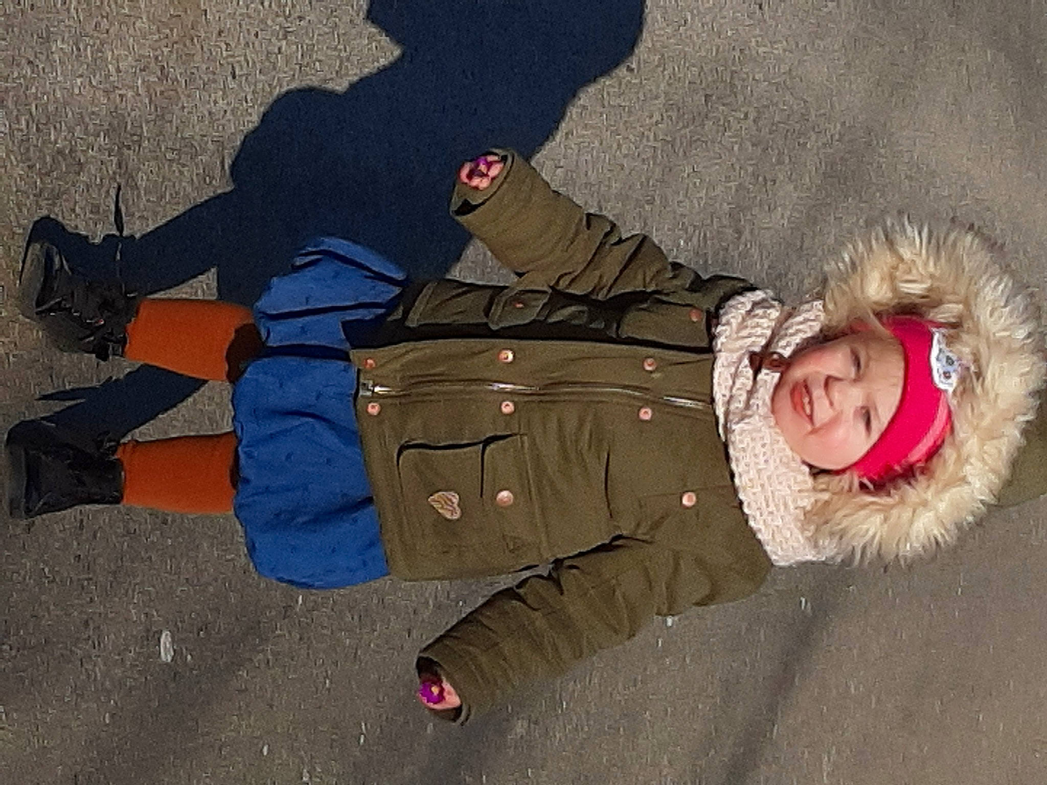 Inaé a rejoint le concours — aidez-le/la à gagner de superbes lots ! asphalt, child, electric_blue, fun, fur, happy, headwear, human_body, jacket, landscape, leisure, parka, person, recreation, road_surface, shadow, sitting, smile, toddler, travel