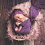 baby, newborn, sleeping, purple_cloth, headband, fluffy_blanket, pink, wooden_floor, wrapped, closeup, peaceful, cute, infant, portrait, cozy, soft_texture, smiling, hands, feet, indoor