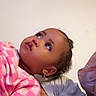 Starr joined the competition — help win amazing prizes! child, toddler, pink_checkered_shirt, curly_hair, earrings, looking_up, adult, resting, indoor, plain_background, portrait, casual_clothing, close_up, expression, person, face, skin, head, comfort, candid