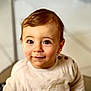 baby, button, child, clothing, cute, expression, eyes, face, hair, indoor, infant, person, portrait, seated, skin, smile, sweater, toddler, warm, young_child