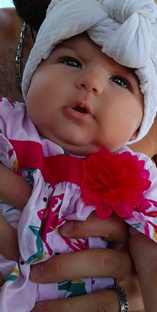 Aliyah participe au concours pour gagner de l'argent avec cette photo : baby_toddler_clothing, cap, cheek, eye, eyebrow, eyelash, face, facial_expression, finger, flower, hand, happy, headgear, headwear, iris, lip, nose, person, pink, skin