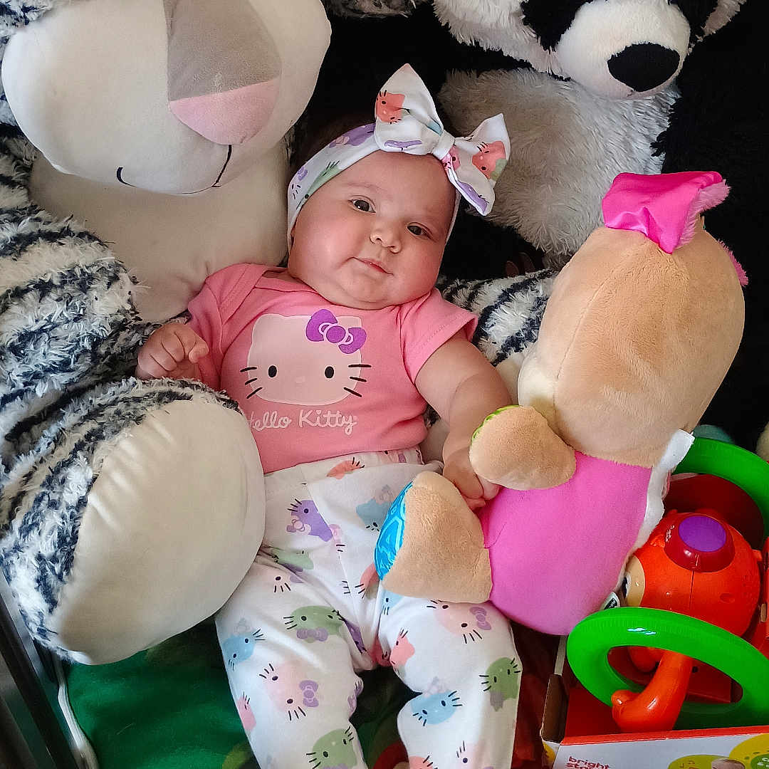 Anahí Sofía joined the competition — help win amazing prizes! baby, bright_colors, child, clothing, colorful, cute, green_blanket, headband, hello_kitty, indoor, infant, lying_down, panda, playful, plush_toy, smiling, soft_toys, stuffed_animal, toy, zebra