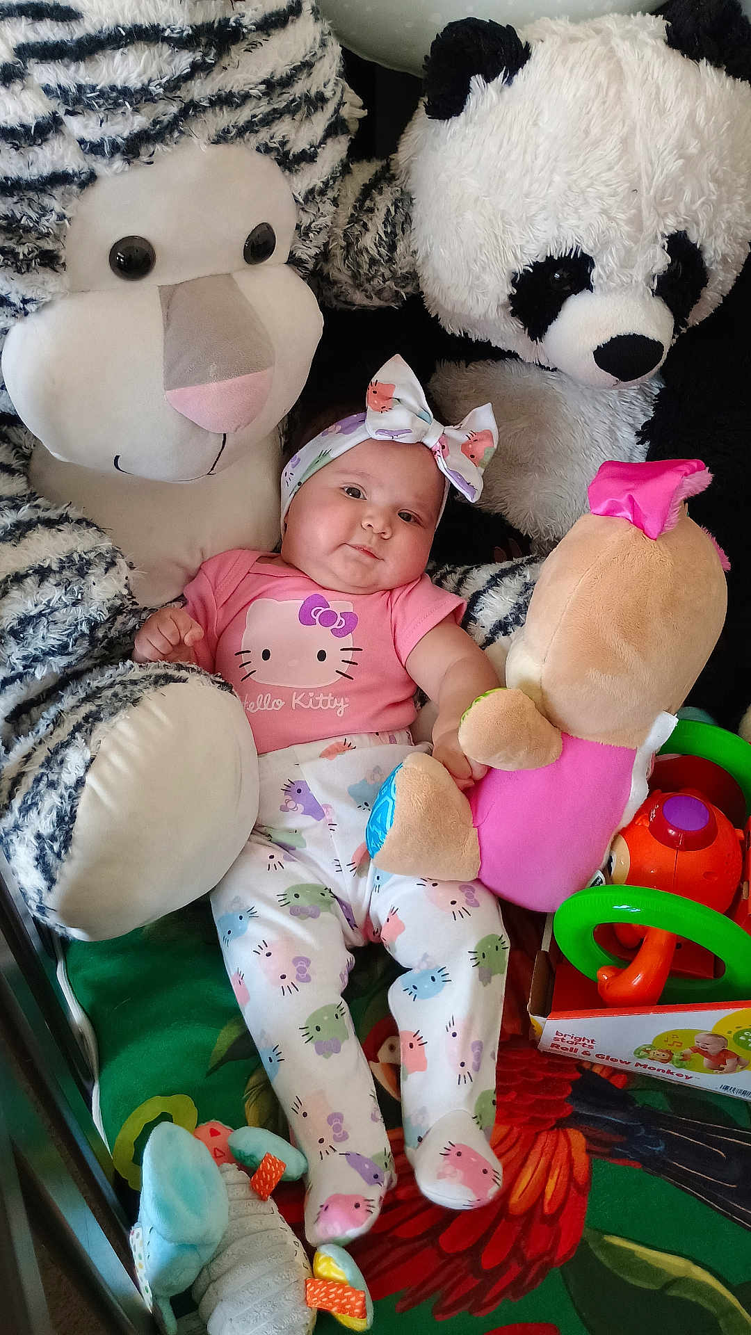 Anahí Sofía joined the competition — help win amazing prizes! baby, bright_colors, child, clothing, colorful, cute, green_blanket, headband, hello_kitty, indoor, infant, lying_down, panda, playful, plush_toy, smiling, soft_toys, stuffed_animal, toy, zebra