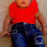 Billie Jean is registered to the contest to win money with this photo: adorable, baby, casual_wear, child, clothing, couch, cozy, cute, denim_jeans, expression, face, heart_patch, indoors, infant, portrait, red_shirt, sitting, skin, sparkles, young_child