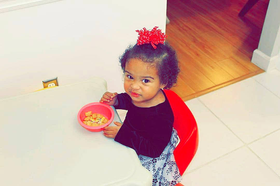 Rosealie is registered to the contest to win money with this photo: arm, baby, baby_toddler_clothing, flooring, fun, happy, magenta, party_supply, pattern, person, play, room, sitting, sleeve, sweetness, t_shirt, tableware, toddler