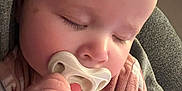 Briar is registered to the contest to win money with this photo: baby, child, closeup, comfort, cozy, cute, eyelashes, face, hand, indoor, infant, napping, newborn, pacifier, peaceful, person, pink_clothing, skin, sleeping, soft_lighting