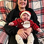 Briar joined the competition — help win amazing prizes! baby, child, girl, smiling, happy, santa_hat, red_clothing, plaid_couch, indoor, holiday_theme, festive, portrait, seated, cozy, person, family, cute, warm, hands, background