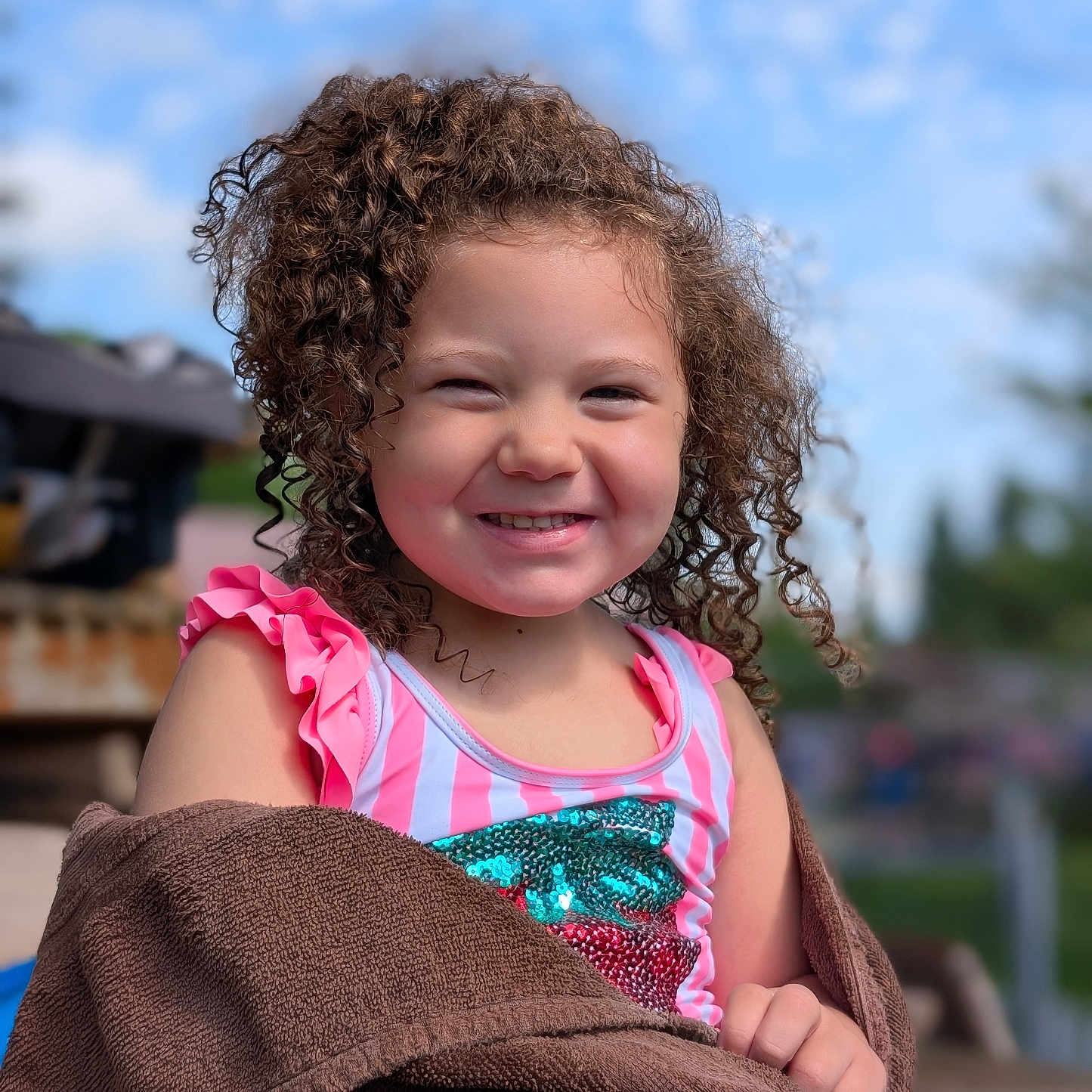 Jaquelyn Marie Kai Wilson joined the competition — help win amazing prizes! blue_sky, child, curly_hair, cute, daylight, fun, girl, happy, nature, outdoor, person, pink_clothing, playful, portrait, sequins, smile, summer, sunny, towel, young