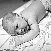 Abel is registered to the contest to win money with this photo: baby, black_and_white, blanket, child, curious, diaper, face, hand, head, indoor, infant, lying_down, monochrome, newborn, pattern, peaceful, portrait, skin, soft_light, young