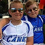 child, boys, sunglasses, aviator, casual_clothing, friendship, outdoor, cafe, smile, portrait, short_hair, relaxing, summer, daylight, reflection, hatless, seated, two_people, cool, fun