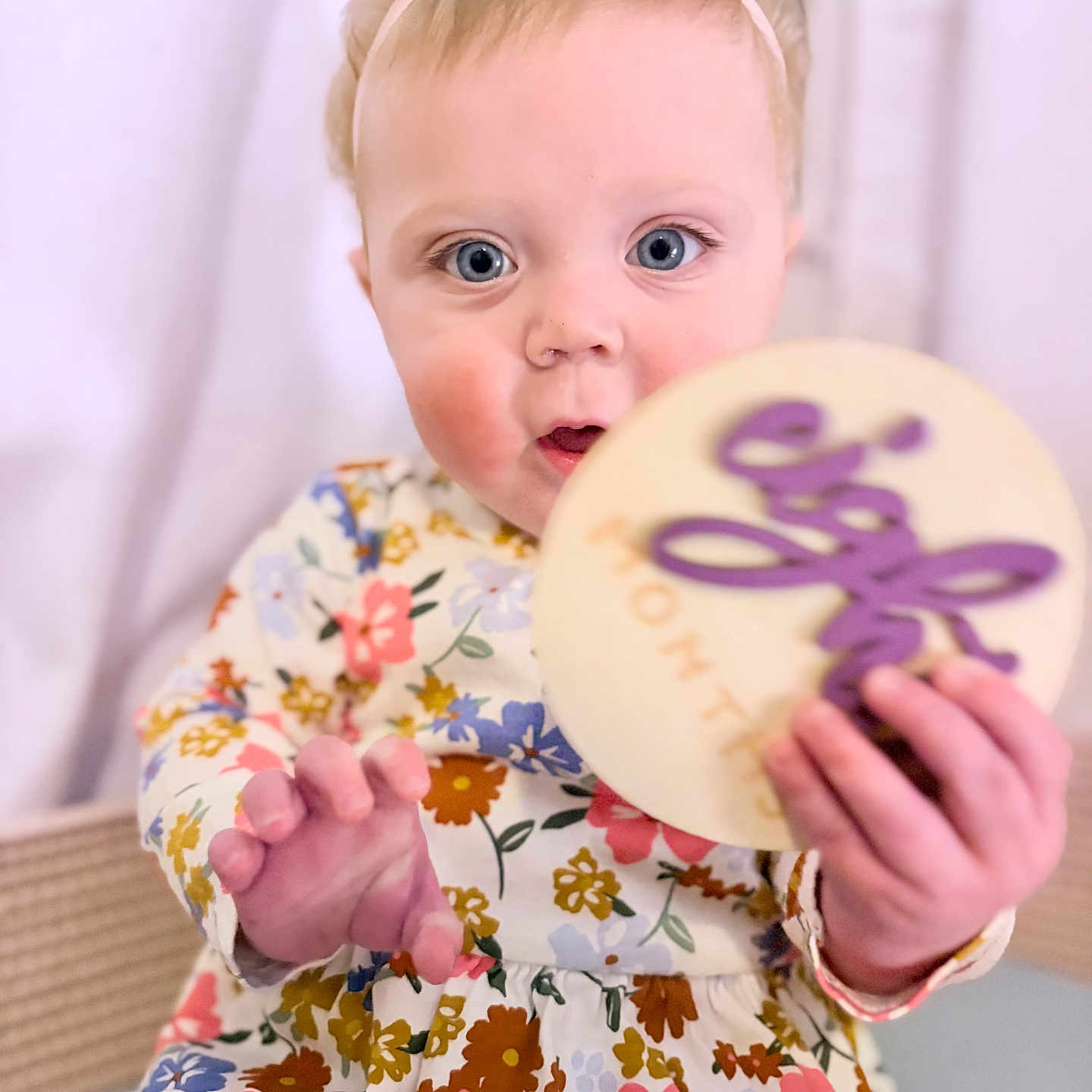 Mabel joined the competition — help win amazing prizes! baby, blue_eyes, child, cookie, cute, dress, expression, face, floral_pattern, flower, food, girl, hand, headband, indoors, pink, portrait, sitting, white, young