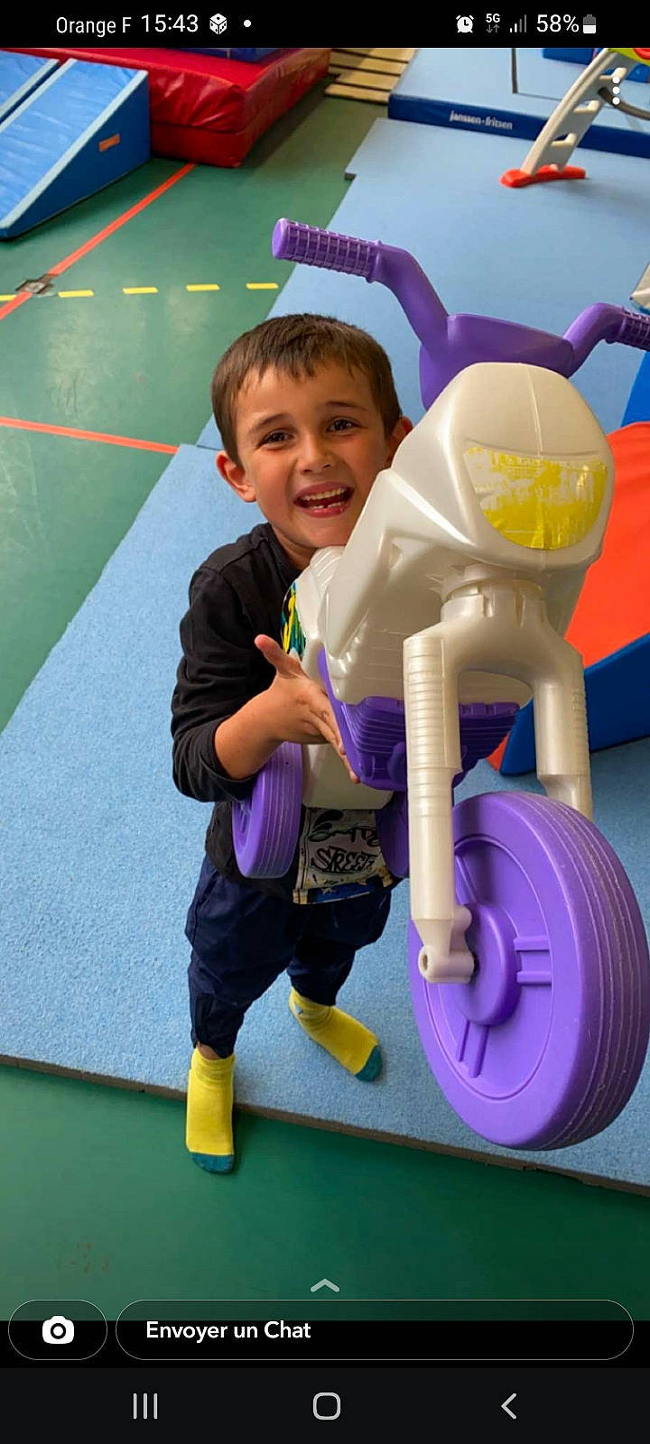 Hugo participe au concours pour gagner de l'argent avec cette photo : automotive_tire, baby_toddler_clothing, blue, child, city, electric_blue, flooring, fun, happy, leisure, person, play, purple, recreation, riding_toy, shorts, smile, tire, toddler, wheel