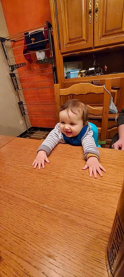 Louis participe au concours pour gagner de l'argent avec cette photo : baby_toddler_clothing, chair, child, crawling, floor, flooring, fun, hardwood, laminate_flooring, person, plank, plywood, skin, smile, table, thumb, toddler, varnish, wood, wood_flooring