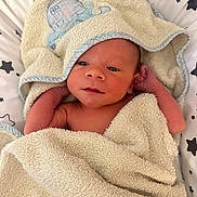 Sacha a rejoint le concours — aidez-le/la à gagner de superbes lots ! newborn, baby, towel, blanket, star_pattern, hooded_towel, infant, skin, face, hands, lying_down, cute, soft_texture, wrapped, bed, resting, indoors, peaceful, closeup, portrait