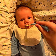 Rafaël a rejoint le concours — aidez-le/la à gagner de superbes lots ! baby, feeding, bib, blanket, hand, spoon, pajamas, infant, face, cute, child, bed, cushion, person, food, meal, indoor, closeup, expression, soft