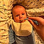 baby, feeding, bib, blanket, hand, spoon, pajamas, infant, face, cute, child, bed, cushion, person, food, meal, indoor, closeup, expression, soft