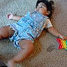toddler, child, carpet, indoor, toy, denim_overalls, yellow_shorts, blue_shirt, playtime, person, kneeling, star_toy, casual, floor, hand, barefoot, candid, young_child, clothing, relaxed