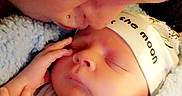 Oliver is registered to the contest to win money with this photo: architecture, baby, blanket, bonnet, building, clothing, face, hat, head, hospital, kissing, newborn, person, photography, portrait, quilt, romantic, sleeping