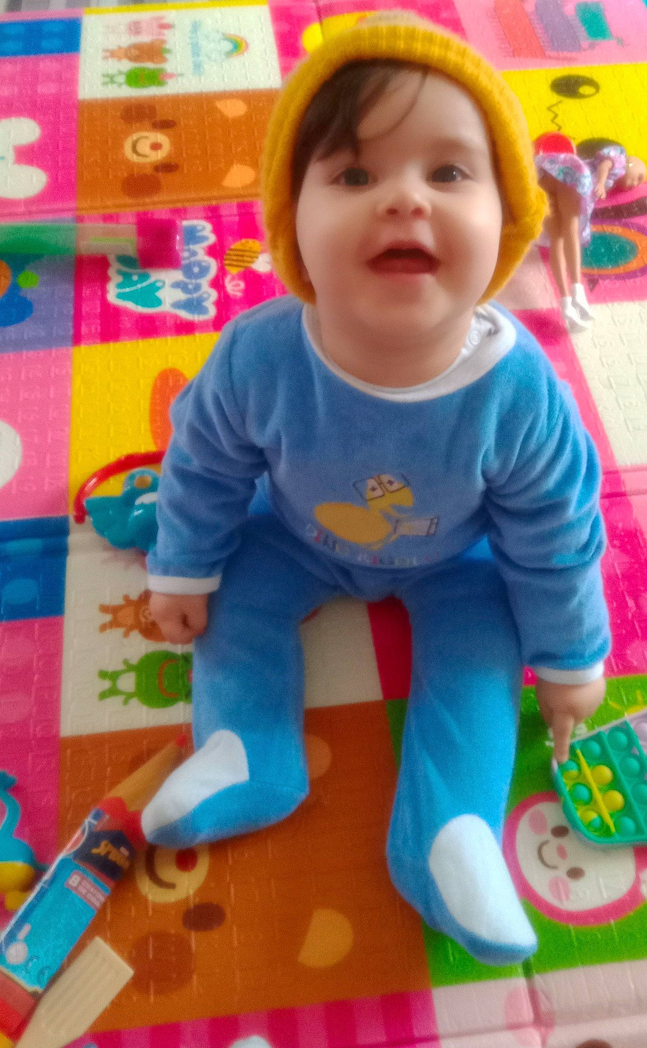 Iris a rejoint le concours — aidez-le/la à gagner de superbes lots ! baby, baby_products, baby_toddler_clothing, cheek, child, flooring, fun, happy, head, pattern, person, play, product, sitting, sleeve, smile, t_shirt, toddler, toy, wheel