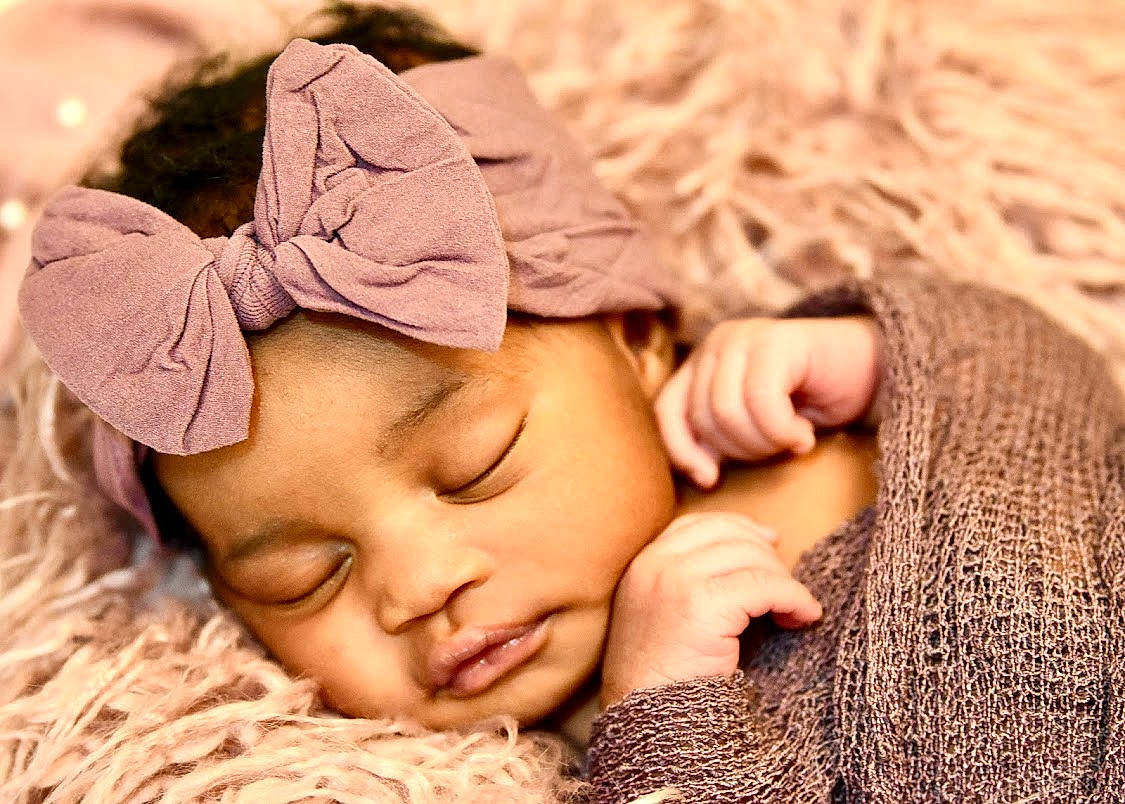Phoenix is registered to the contest to win money with this photo: baby, baby_sleeping, bedtime, child, comfort, fashion_accessory, fur, gesture, grass, hair_accessory, happy, headpiece, headwear, linens, nail, nap, person, sand, skin, textile