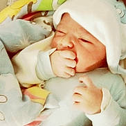 يحيى participe au concours pour gagner de l'argent avec cette photo : newborn, baby, infant, blanket, hat, hand, sucking, face, sleepwear, cozy, cute, child, soft, pastel_colors, indoors, portrait, resting, wrapped, comfort, warm