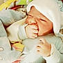 newborn, baby, infant, blanket, hat, hand, sucking, face, sleepwear, cozy, cute, child, soft, pastel_colors, indoors, portrait, resting, wrapped, comfort, warm