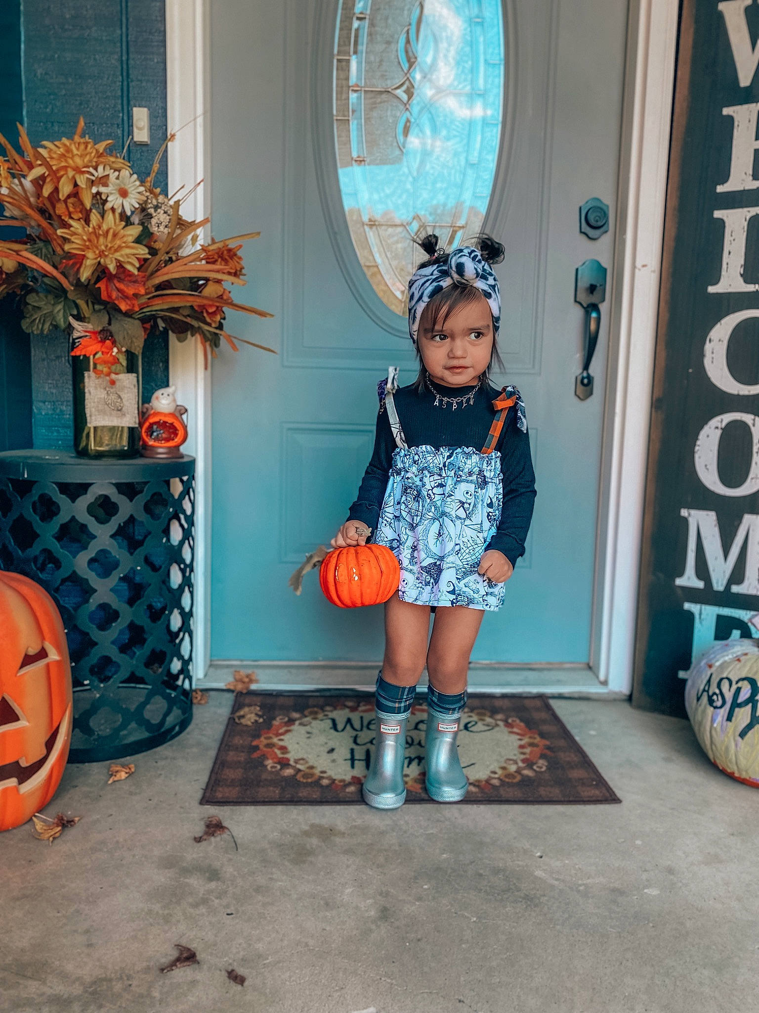 Aspyn is registered to the contest to win money with this photo: aqua, azure, blue, calabaza, cucurbita, door, dress, electric_blue, fashion_design, gourd, human_leg, orange, pattern, person, pumpkin, sock, standing, street_fashion, textile, toddler