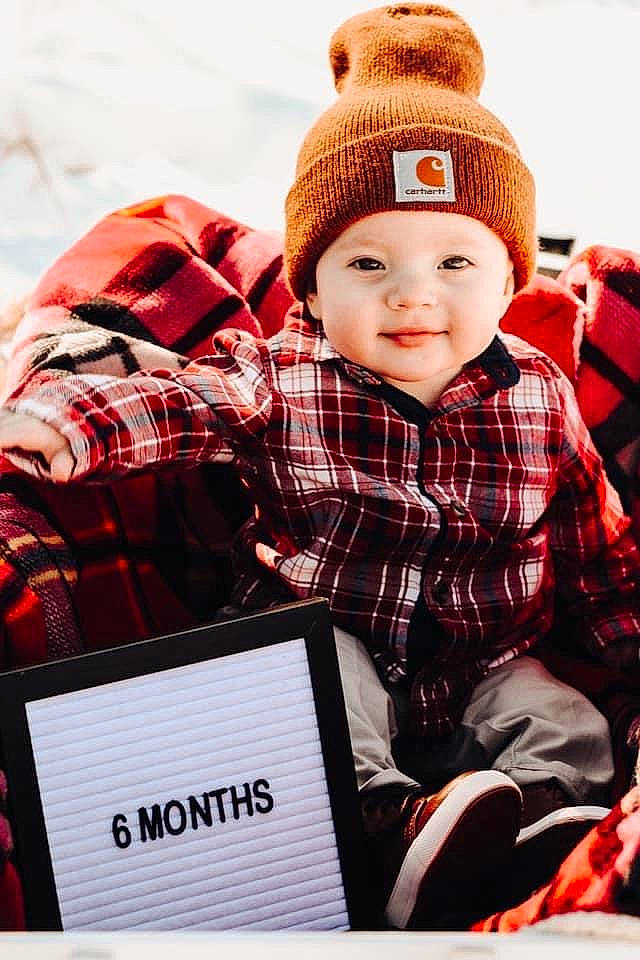 Zeplyn is registered to the contest to win money with this photo: baby_toddler_clothing, cap, child, christmas, design, event, happy, headwear, holiday, joy, pattern, person, plaid, product, red, sitting, sleeve, smile, tartan, textile