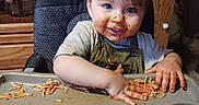 Mason is registered to the contest to win money with this photo: baby, bodypart, cutlery, eating, face, finger, food, furniture, hand, happy, head, lunch, meal, person, photography, plywood, portrait, smile, snack, wood