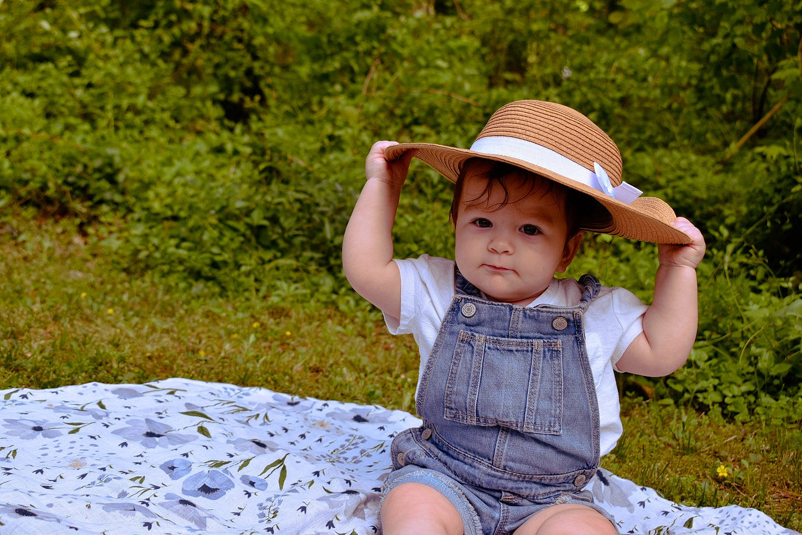 Emmersyn is registered to the contest to win money with this photo: baby, child, fashion_accessory, fun, grass, hat, headgear, leaf, male, person, photograph, photography, recreation, sitting, skin, smile, summer, sun_hat, toddler, tree