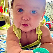 Emery is registered to the contest to win money with this photo: baby, infant, child, teething_toy, blanket, play_area, curious, cute, indoors, closeup, face, hand, blue_eyes, green_clothing, plaything, chubby_cheeks, expression, floor, colorful, safe_environment