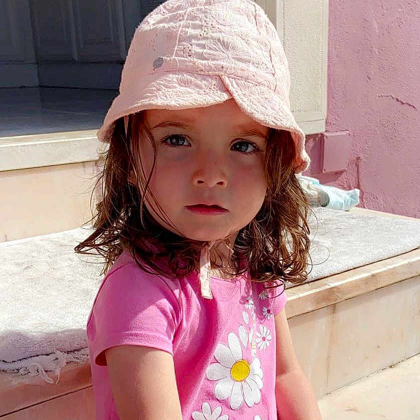 Maëlie participe au concours pour gagner de l'argent avec cette photo : baby_toddler_clothing, cap, child, door, fashion_accessory, fun, happy, hat, magenta, peach, pink, portrait_photography, sitting, sleeve, summer, toddler, vacation