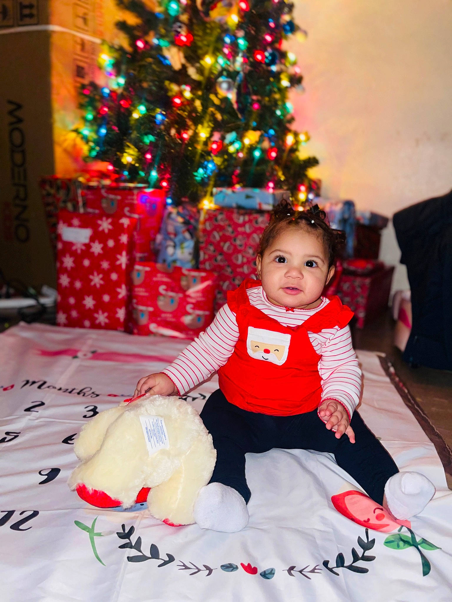 Khamari joined the competition — help win amazing prizes! baby_toddler_clothing, child, christmas, christmas_decoration, christmas_eve, christmas_ornament, christmas_tree, event, evergreen, fun, happy, holiday, person, photograph, plant, sitting, smile, toddler, tradition, tree