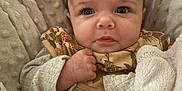 Maribel is registered to the contest to win money with this photo: baby, infant, blanket, cozy, cute, face, expression, fist, clothing, patterned, portrait, soft, warm, indoors, child, newborn, comfort, cushion, laying, resting