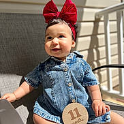 Amy joined the competition — help win amazing prizes! baby, child, denim_dress, red_bow, headband, milestone_sign, 11_months, outdoor, sunlight, smiling, happy, sitting, chair, cute, infant, portrait, footwear, baby_shoes, skin, person