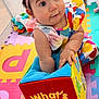 Amy joined the competition — help win amazing prizes! baby, child, toy, plush_toy, colorful_clothing, headband, play_mat, indoor, curious, sitting, soft_toy, infant, cute, colorful, patterned_clothing, hands, face, foot, playtime, exploring