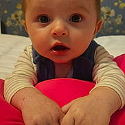 Elyo participe au concours pour gagner de l'argent avec cette photo : baby, infant, hands, face, eyes, curious, pink_cushion, striped_clothing, bed, room, wallpaper, floral_pattern, portrait, child, young, indoor, skin, expression, cute, looking