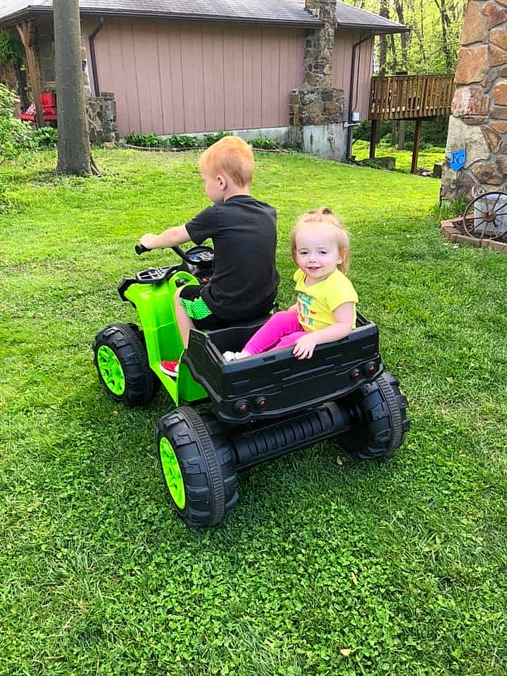 Bri is registered to the contest to win money with this photo: backyard, car, grass, joy, lawn, outdoor_power_equipment, person, play, riding_mower, riding_toy, toddler, vehicle, yard