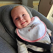 Lylou participe au concours pour gagner de l'argent avec cette photo : baby, infant, smile, bib, gray_cushion, seat_belt, indoors, window, natural_light, face, clothing, cute, child, happy, person, portrait, soft_light, seat, comfort, baby_bib