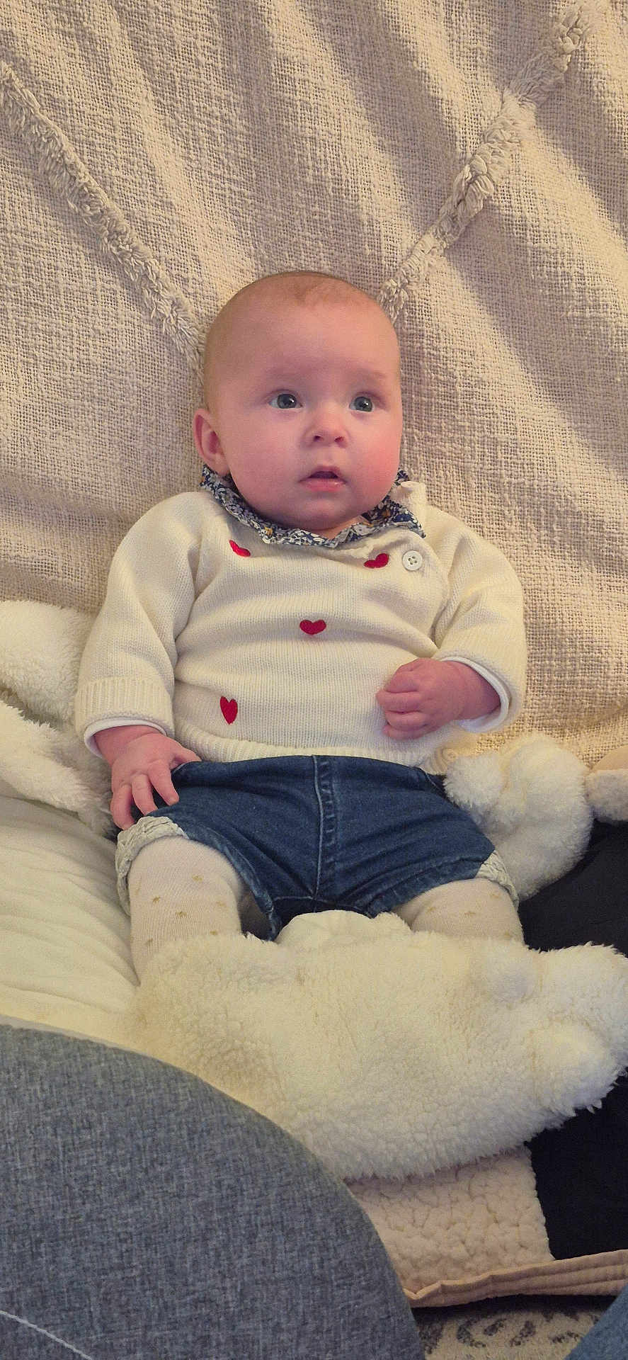 Lylou a rejoint le concours — aidez-le/la à gagner de superbes lots ! baby, child, infant, sitting, sweater, denim_shorts, blanket, cozy, cute, indoors, portrait, face, expression, soft_toys, fabric, warm_clothing, curious, hands, head, texture