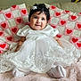baby, infant, smile, white_dress, lace, cute, child, portrait, soft_blanket, pink, hearts, quilt, happy, indoors, candid, socks, black_hair, bow, sitting, cozy