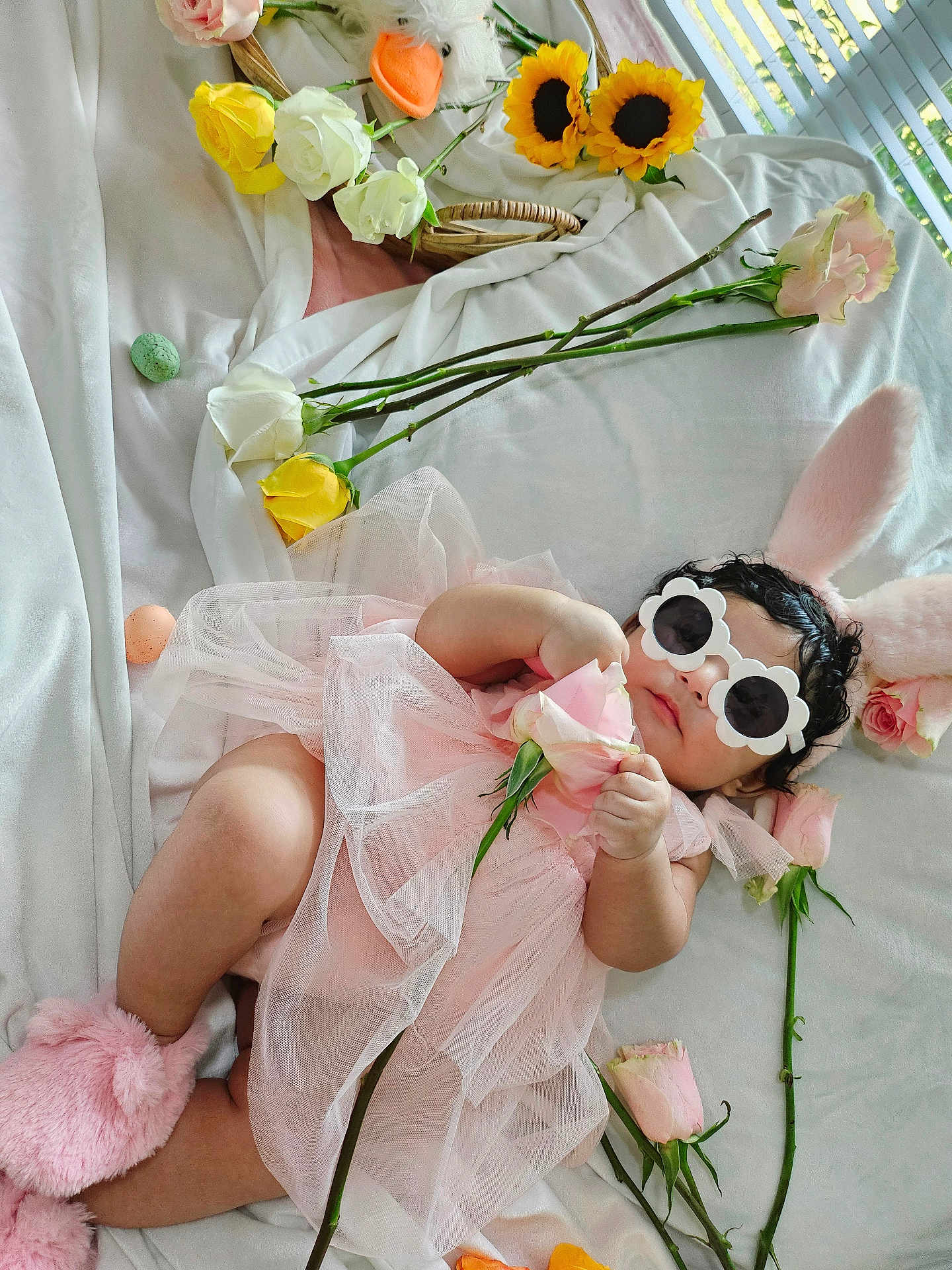 Merida is registered to the contest to win money with this photo: baby, pink_dress, bunny_ears, sunglasses, roses, sunflowers, blanket, flower, infant, cute, fluffy_slippers, tulle, lying_down, indoor, decorative_flowers, soft_texture, child, headwear, accessories, relaxing